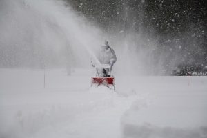 A man clears snow with a Honda snowblower in the dead of winter.